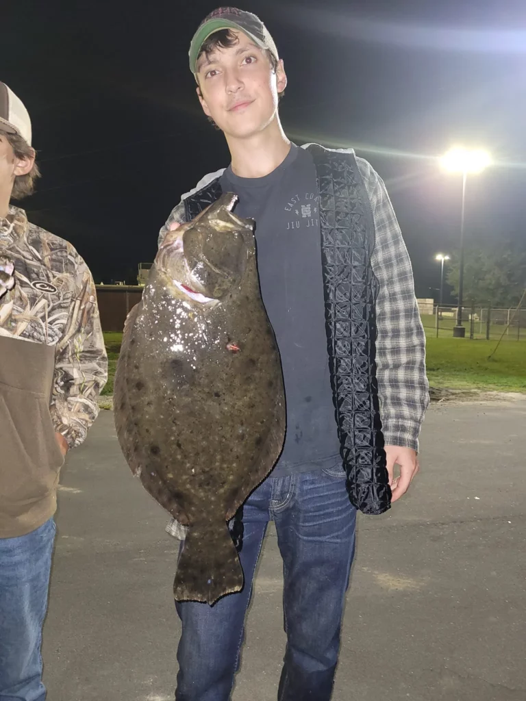 Guest holding a longnose gar caught bowfishing at night