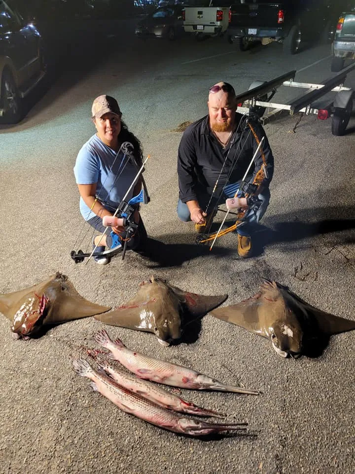 Guest with a bowfin catch on a night bowfishing trip